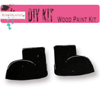 a pair of black wood paint sitting on top of a white surface