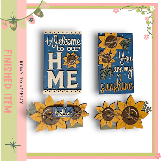 two wooden signs with floral designs and text, including a welcome message and a message about sunshine.