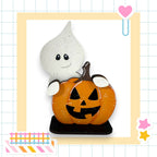 A Halloween-themed decoration featuring a ghost and a carved pumpkin.