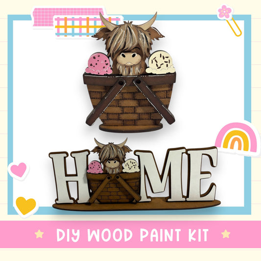 The image is a DIY wood paint kit featuring a wooden basket with a cute cartoon character inside, and a wooden sign with the word "HOME" on it.