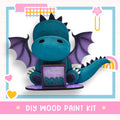 a blue dragon sitting on top of a purple box