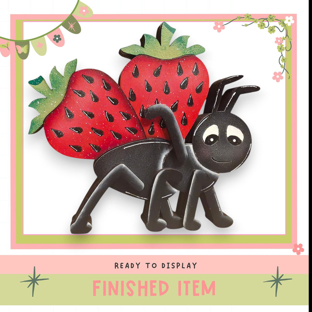 a black ant carrying a red strawberry on its back, with a pink and green border and decorative elements.