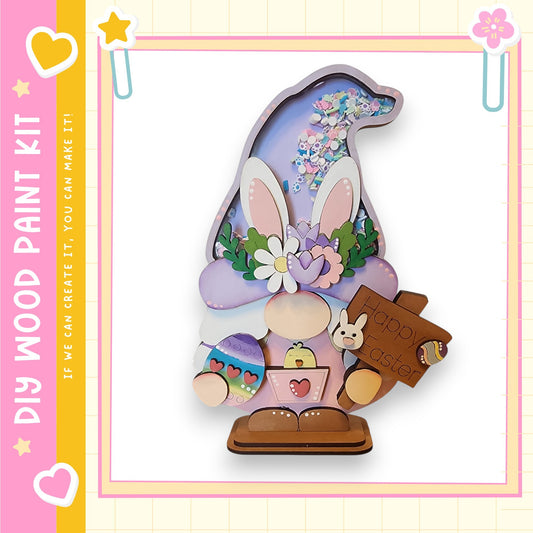 A wooden Easter decoration kit featuring a gnome-like figure with a bunny head, holding a sign that says "Happy Easter".