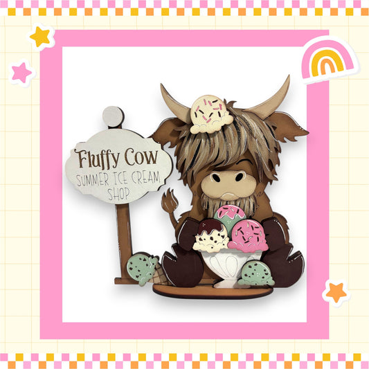 Fluffy Cow, a wooden cow figurine, is sitting on a wooden base and holding a sign that says "Fluffy Cow Summer Ice Cream Shop".