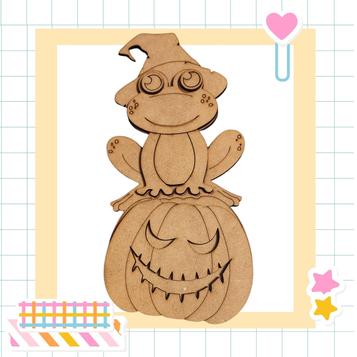 A wooden frog wearing a witch's hat sits atop a carved pumpkin with a carved face, surrounded by colorful stickers and a heart-shaped clip.