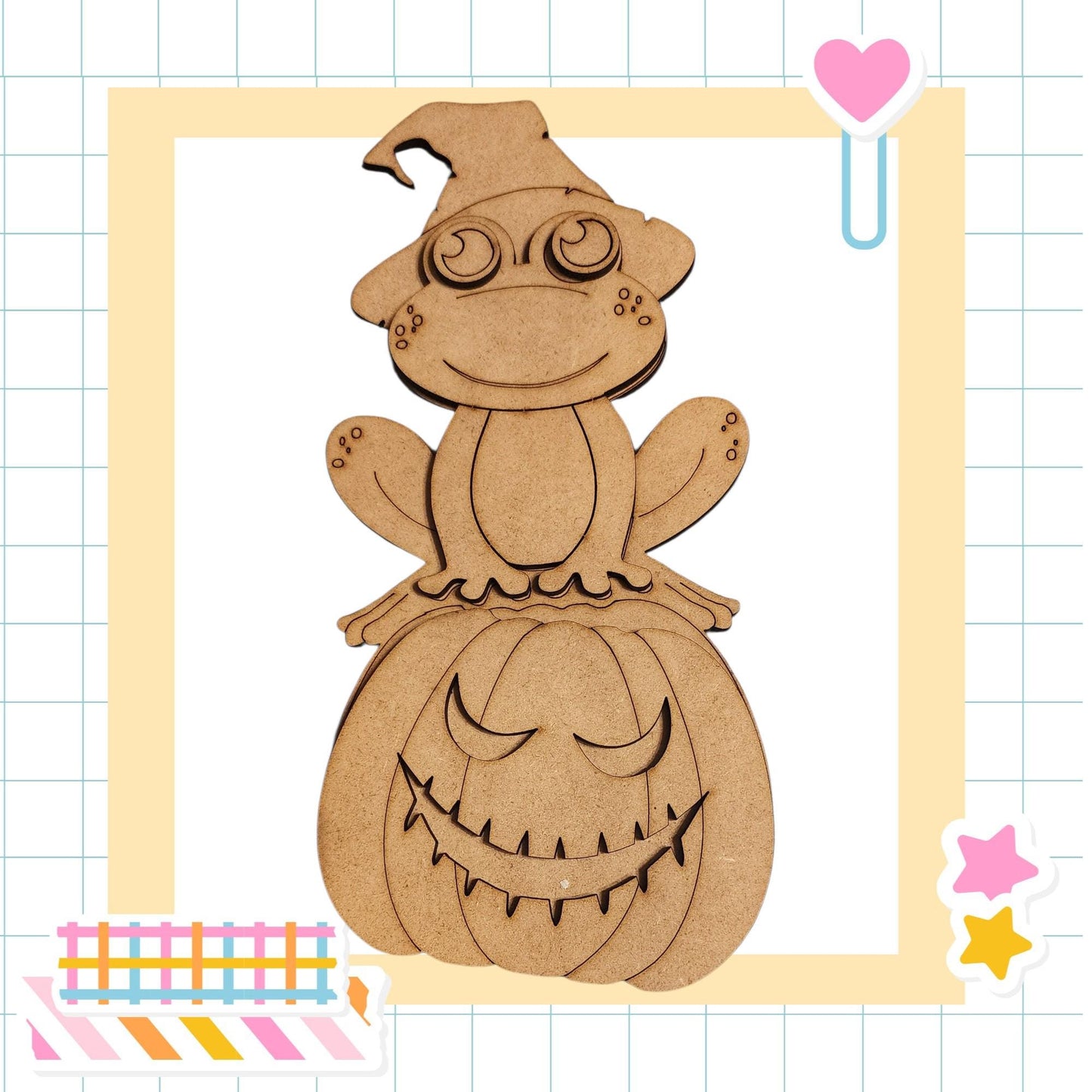 A wooden frog wearing a witch's hat sits atop a carved pumpkin with a carved face, surrounded by colorful stickers and a heart-shaped clip.
