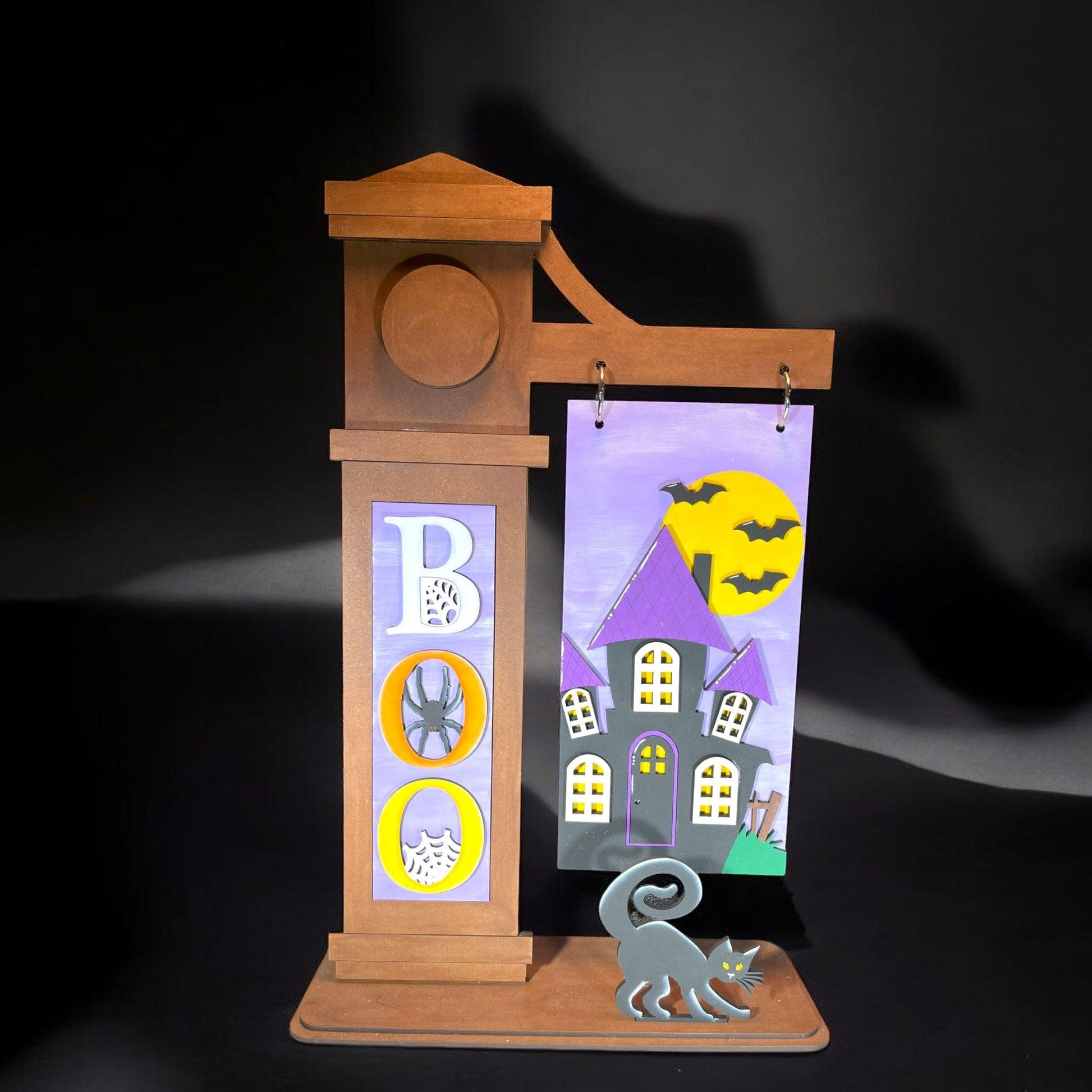 a wooden clock with a picture of a house and a cat