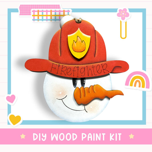 A wooden snowman wearing a red firefighter hat with a flame emblem, smiling and holding a carrot, against a white background with various colorful stickers and a rainbow.