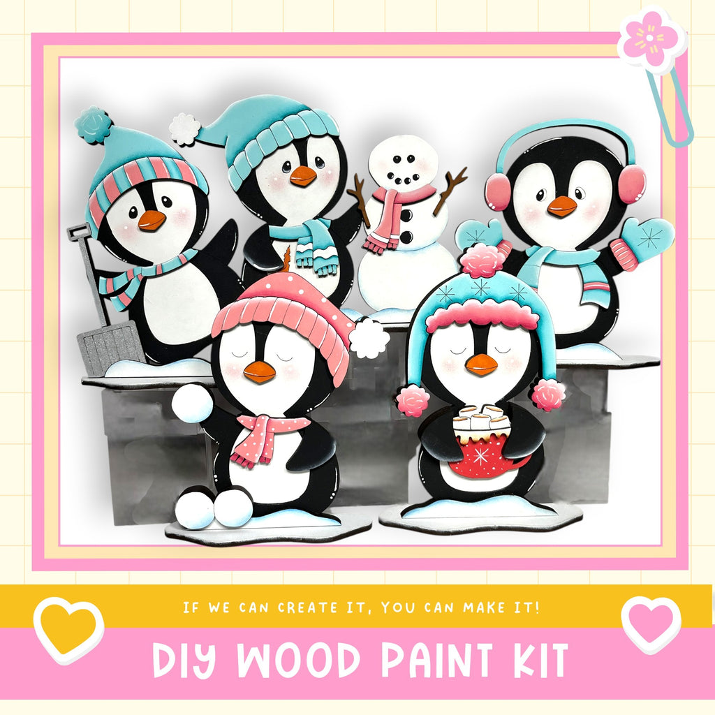 A group of colorful wooden penguin figurines, each wearing winter accessories, are arranged in a playful scene.