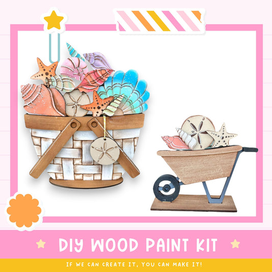 a DIY wood paint kit, with a basket filled with various seashells and starfish, and a wooden wheelbarrow with seashells and starfish on top. The kit appears to be made of wood and is designed for creating custom painted designs using the provided seashells and starfish.