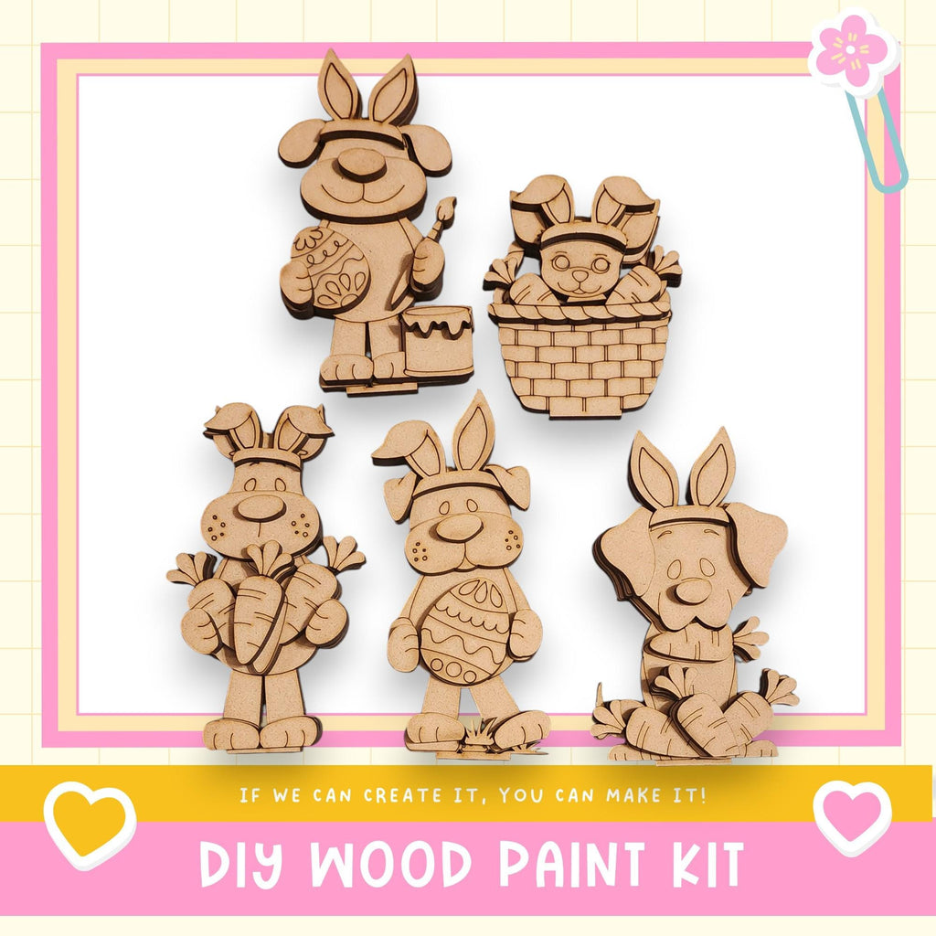 a DIY wood paint kit for creating wooden Easter bunny decorations. There are five wooden Easter bunny figures, each with unique designs and accessories, displayed against a pink and white background.