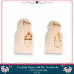 two wooden cutouts of smiling faces, each with a heart-shaped cutout in their pockets. The cutouts appear to be part of a DIY kit for creating wooden figures with heart-shaped cutouts.