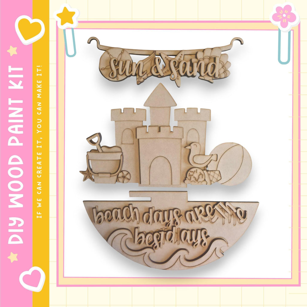 The image is a wooden paint kit featuring a castle, beach ball, and sandcastle, along with the text "Sun & Sand" and "beach days are the best days".