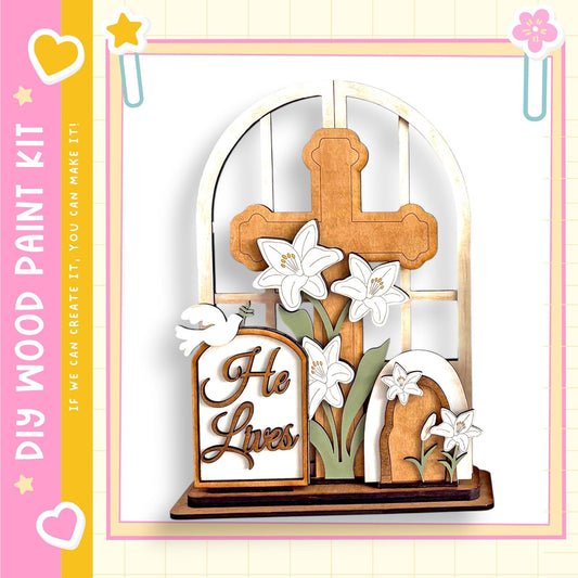 A wooden cross with white flowers and a sign that says "He Lives" is displayed against a white background.