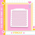a DIY wood paint kit with a pink background and a white stencil with a pattern of pink triangles.
