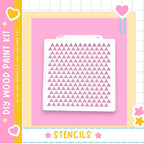 a DIY wood paint kit with a pink background and a white stencil with a pattern of pink triangles.