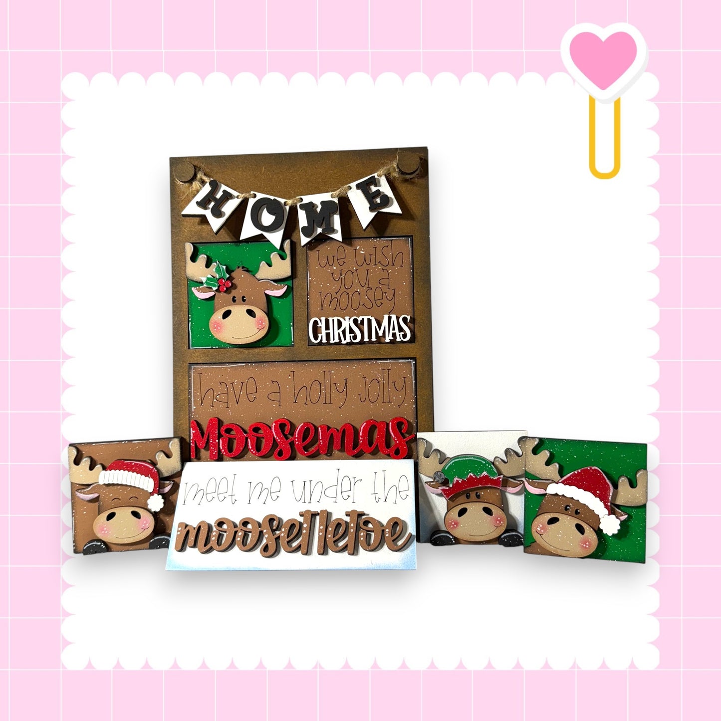 a festive display with a moose head and a heart-shaped decoration, along with a sign that says "Home" and "Christmas".