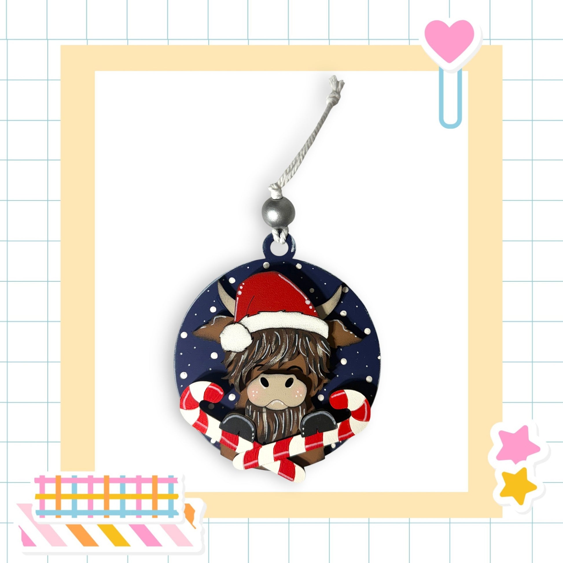 A round ornament featuring a cartoon character wearing a Santa hat, surrounded by candy canes and a heart-shaped charm.