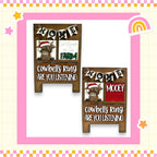 two wooden signs with a cartoon cow and the text "Home" and "Cows are Ring Are You Listening" written on them.