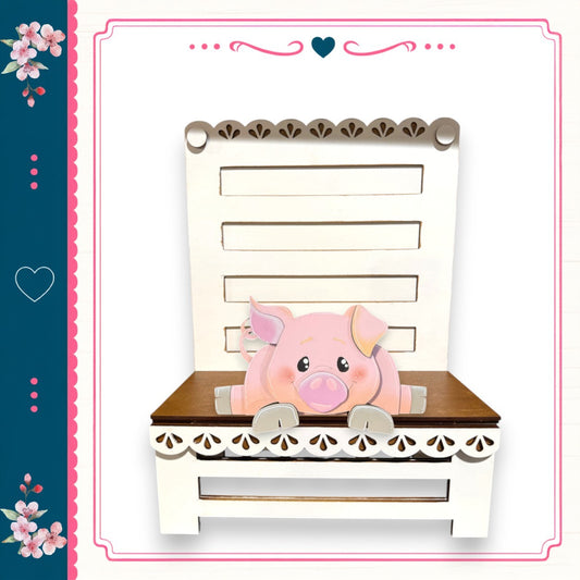 A pink pig sitting on a white wooden bench with decorative trim, surrounded by a floral border.