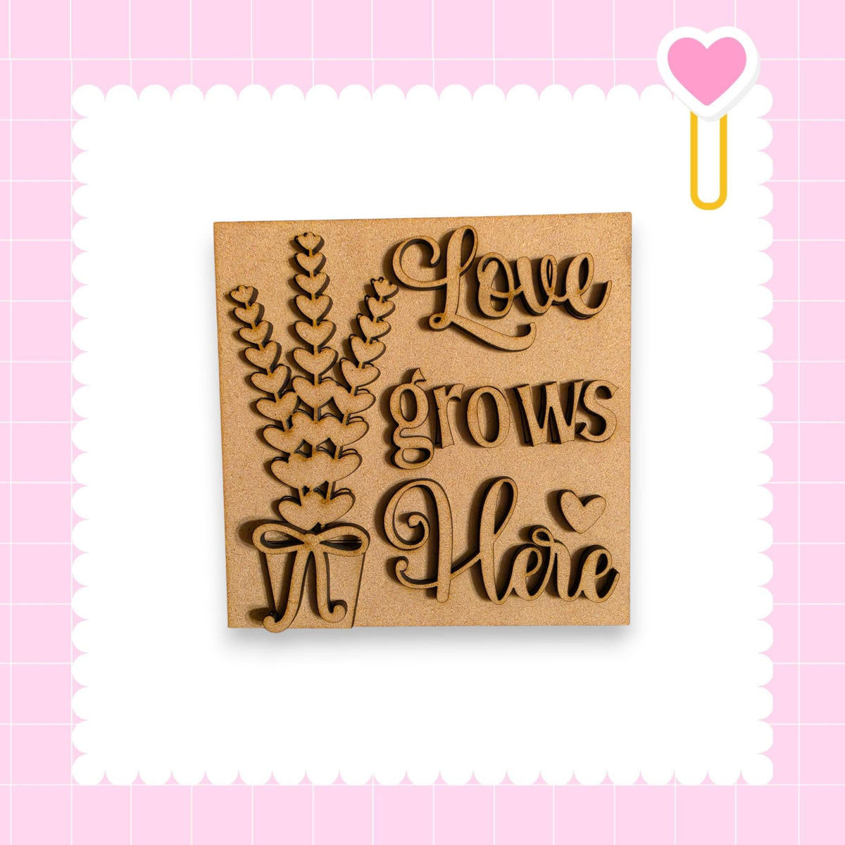 a wooden sign with the text "Love grows here" carved into it, surrounded by a decorative border.