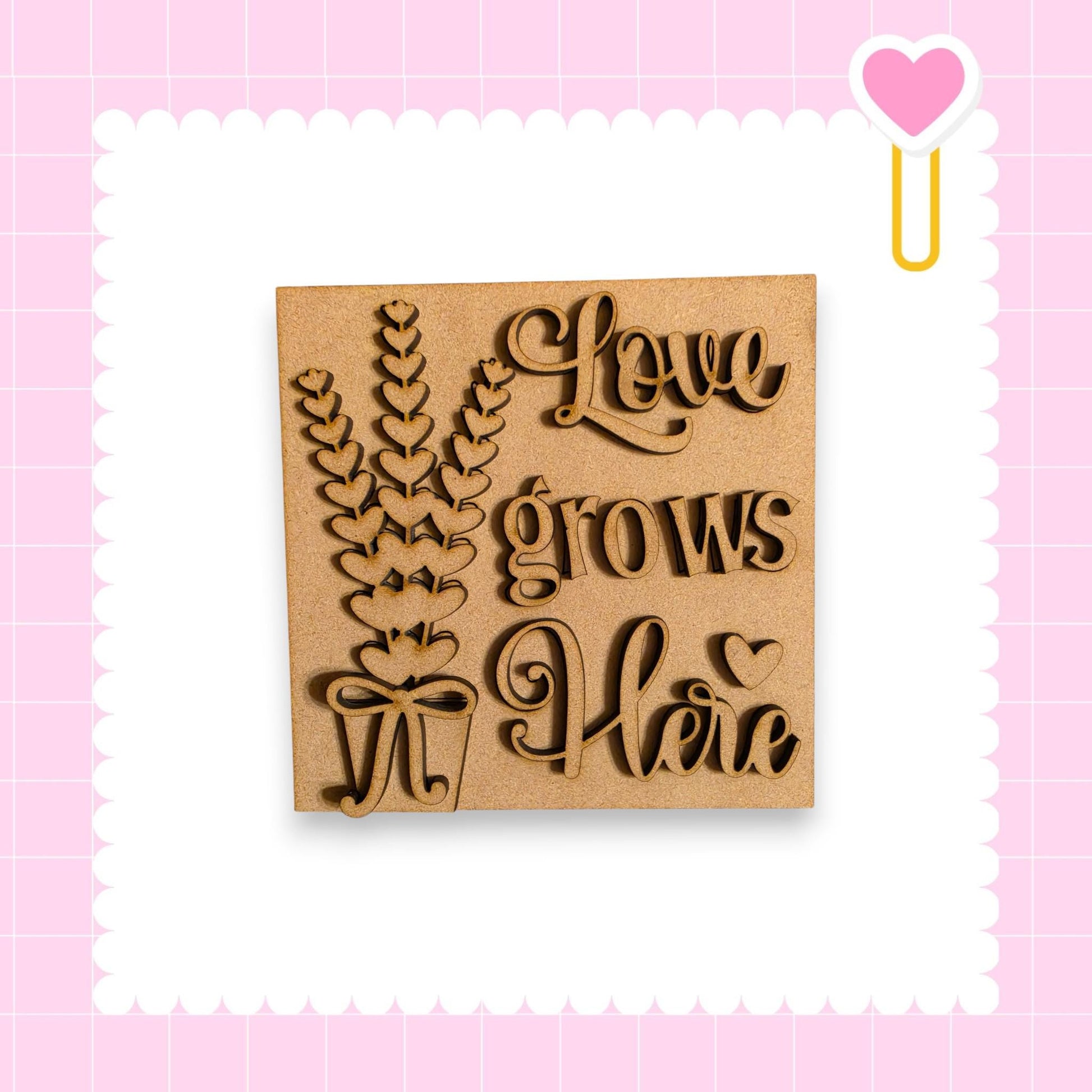 a wooden sign with the text "Love grows here" carved into it, surrounded by a decorative border.