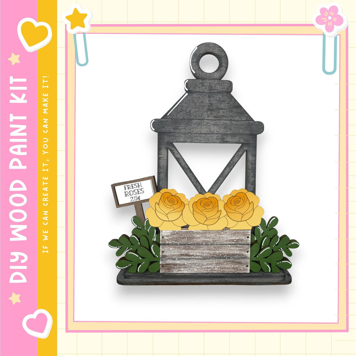 A wooden lantern with a sign that reads "Fresh Roses" is displayed in a vase with yellow roses, surrounded by greenery.