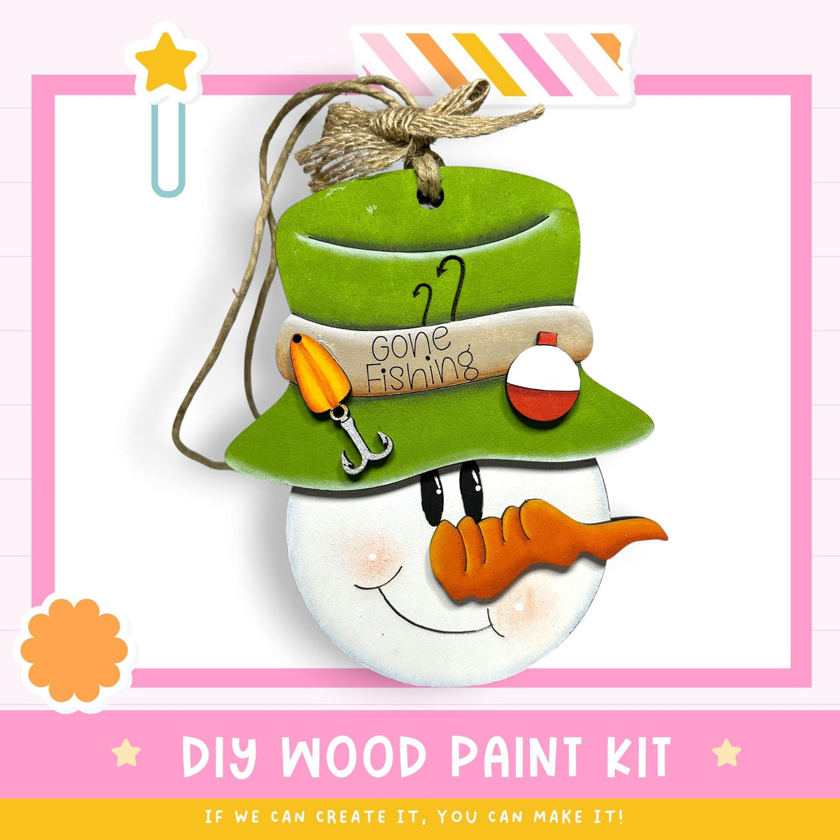 a snowman ornament with a hat, carrot nose, and fishing pole, hanging from a string. The text below the image reads "DIY WOOD PAINT KIT" and "IF WE CAN CREATE IT, YOU CAN MAKE IT!"