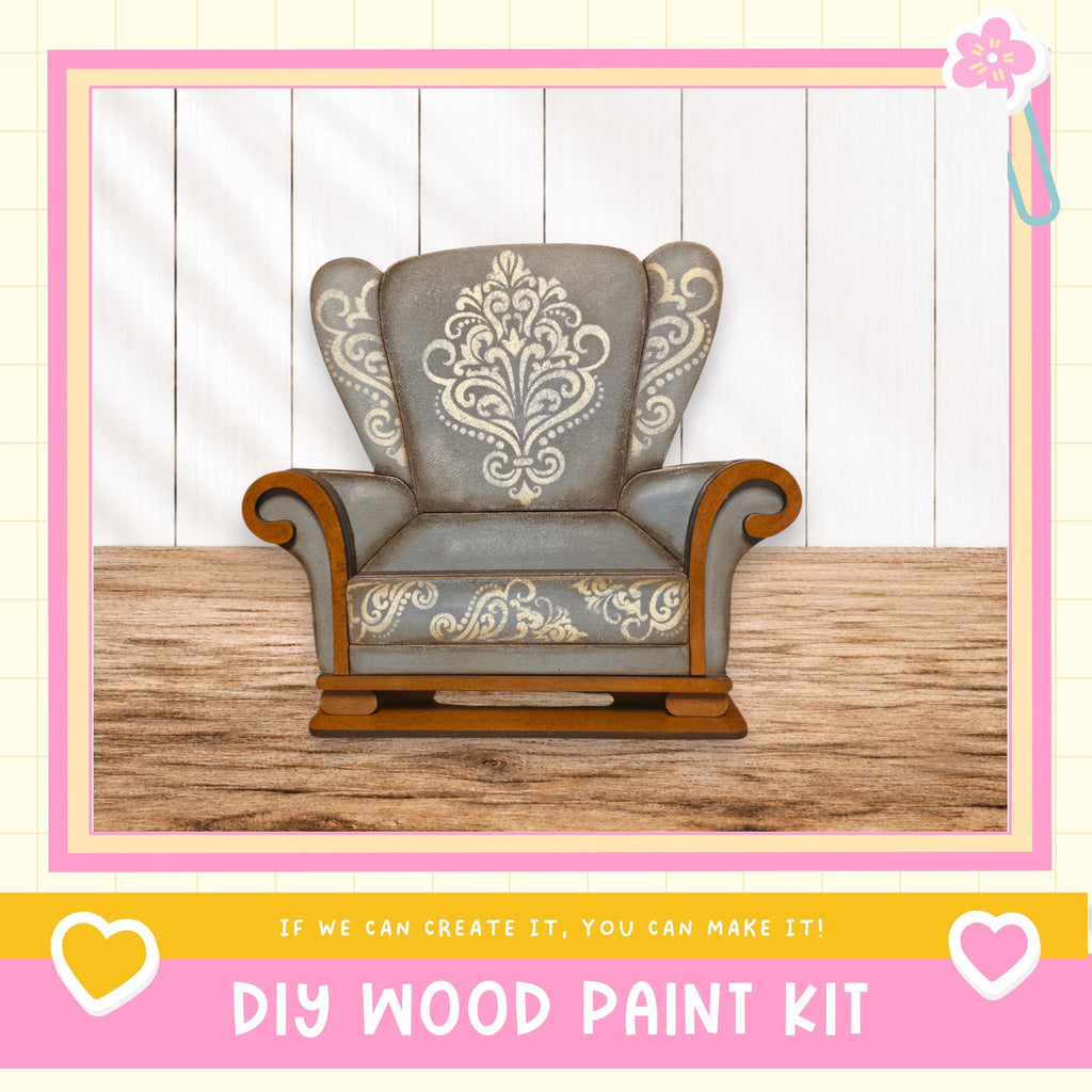 a gray armchair with a floral pattern on the backrest, placed on a wooden floor against a white wall.