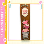 a wooden sign with a decorative design, including heart shapes and cupcake-like elements, and the text "Hello Sweets" written on it.