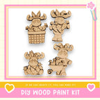 The image is a DIY wood paint kit featuring four wooden animal figurines, including a moose, a bear, a deer, and a rabbit, each holding carrots. The kit appears to be designed for children to create their own wooden animal characters.