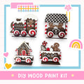 The image is a DIY wood paint kit featuring various wooden train car designs, including a train car with a gingerbread man, a train car with a gingerbread house, and a train car with a gingerbread man and a gingerbread house.