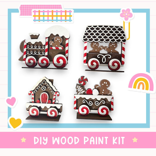 The image is a DIY wood paint kit featuring various wooden train car designs, including a train car with a gingerbread man, a train car with a gingerbread house, and a train car with a gingerbread man and a gingerbread house.