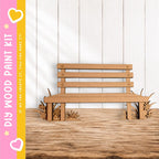 A wooden bench made of cardboard is placed on a wooden floor against a white wall.