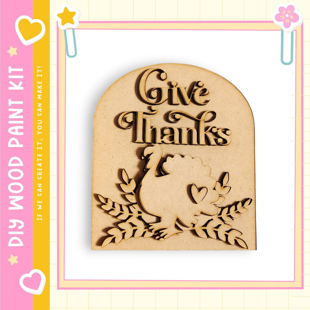 A wooden sign with the text "Give Thanks" carved into it, surrounded by leaves and a turkey silhouette.