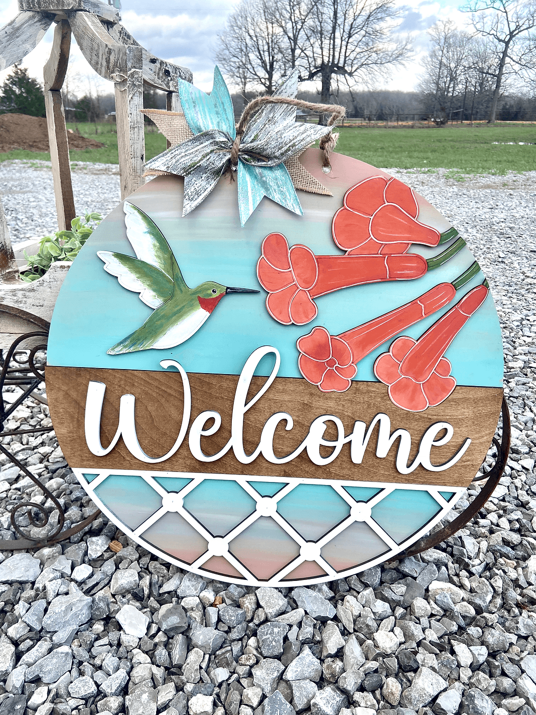 a welcome sign with a bird and flowers on it