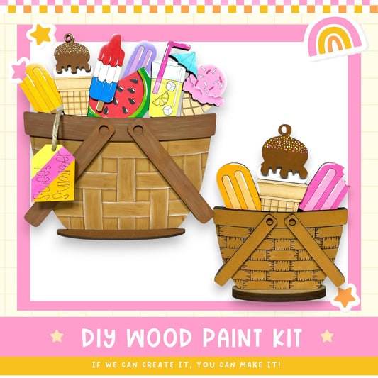 The image is a colorful and playful DIY wood paint kit, featuring two wooden baskets filled with various colorful and whimsical items such as ice cream, popsicles, and other playful objects. The text "DIY WOOD PAINT KIT" is prominently displayed, along with the encouraging message "If we can create it, you can make it!"