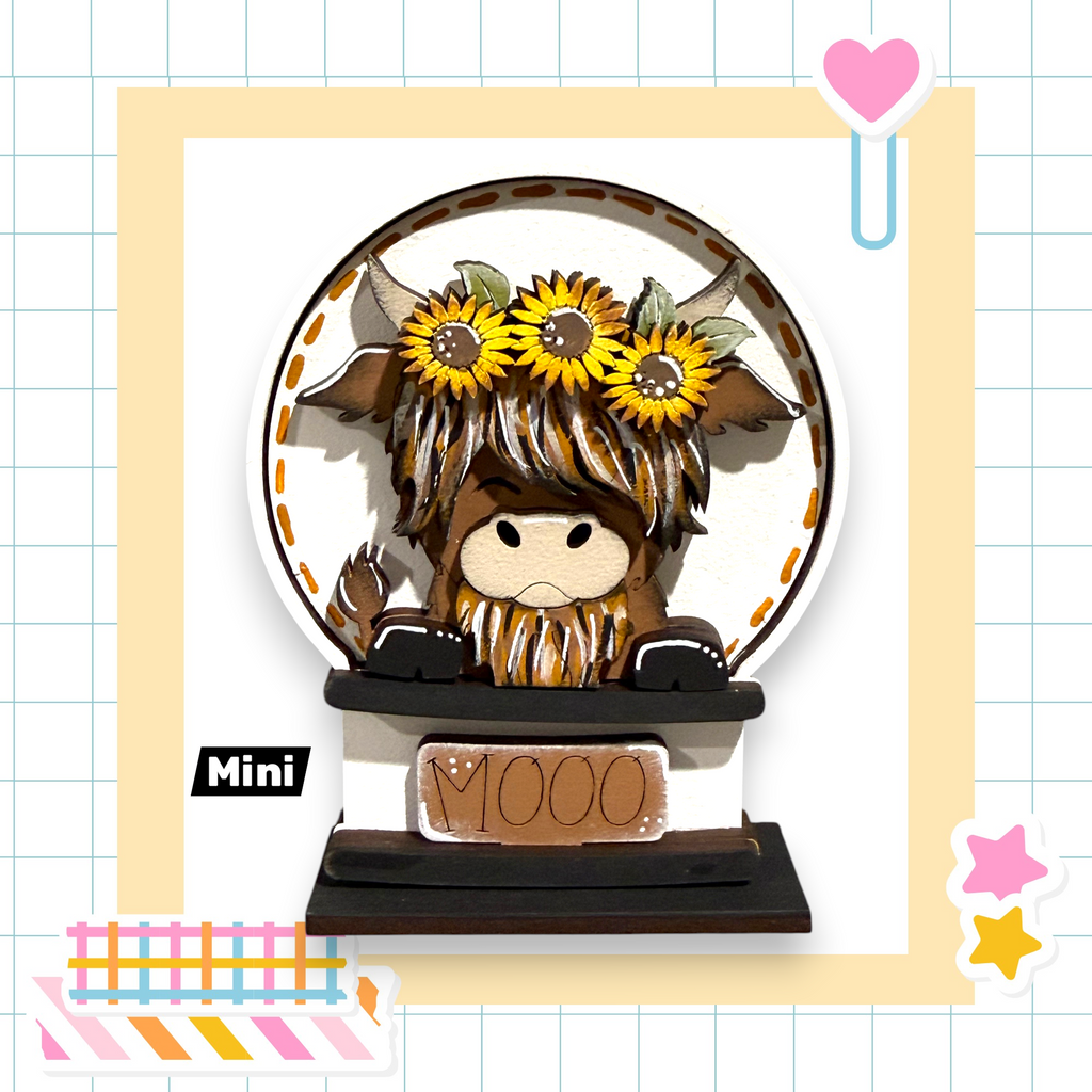 A wooden figurine of a cow with a flower crown, sitting on a black base with the word "MOO" written on it.