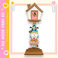 A wooden gnome figurine holding a honey pot, with a small house-like structure above it.