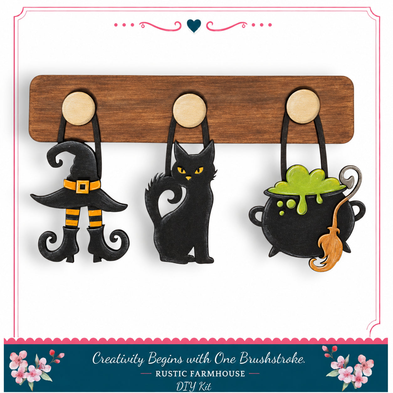 A DIY kit featuring a wooden board with three Halloween-themed charms hanging from it, including a witch's hat, a black cat, and a cauldron with a green substance.