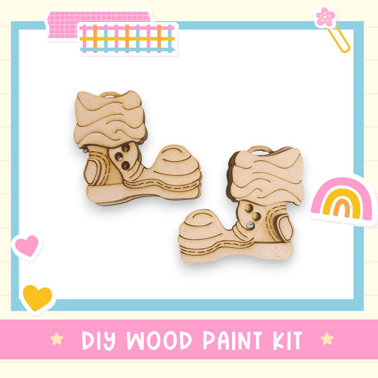a DIY wood paint kit, with two wooden slippers as the main focus. The slippers are made of wood and appear to be ready for painting. The kit is presented in a colorful and playful manner, with various decorative elements surrounding the slippers.