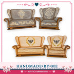 a collection of hand-painted furniture, including two armchairs and a sofa, with intricate floral designs. The furniture appears to be handmade and is displayed in a rustic farmhouse style.