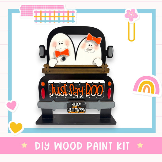 A Halloween-themed DIY wood paint kit featuring a black truck with two white ghost characters sitting in the back, along with a "Just Say 'Doo" sign.
