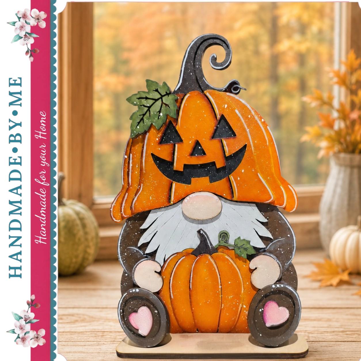 A handcrafted wooden gnome figure holding a carved pumpkin, set against a backdrop of autumn leaves and a window.