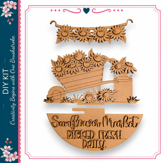 The image is a wooden craft depicting a sunflower market scene, with a wooden cart filled with sunflowers and a sign that reads "Sunflower Market Picked Fresh Daily".