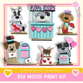 The image is a collage of six wooden paint kits featuring various cartoon dog characters, including a puppy kissing booth, a dog with a heart-shaped sign, and other playful designs.