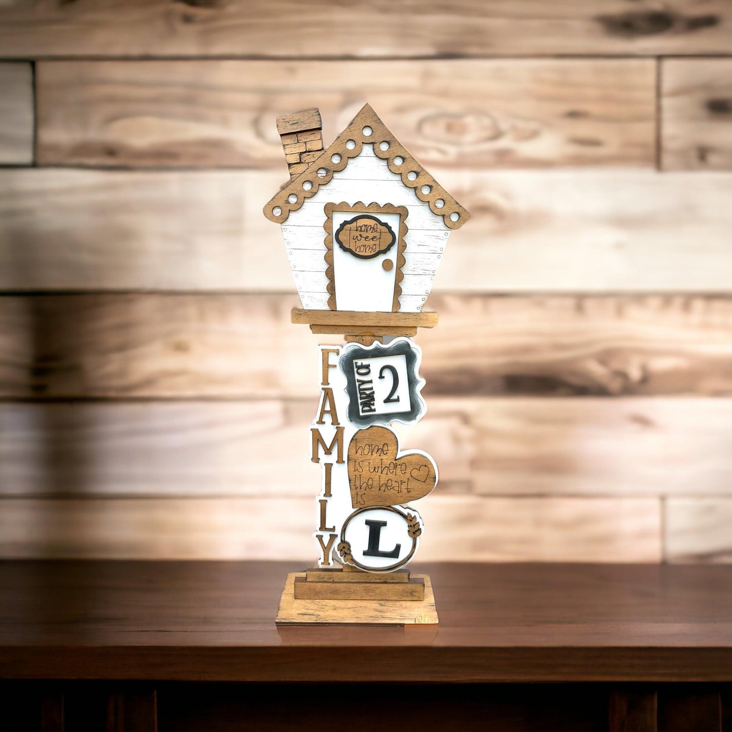 a wooden clock with a house on top of it