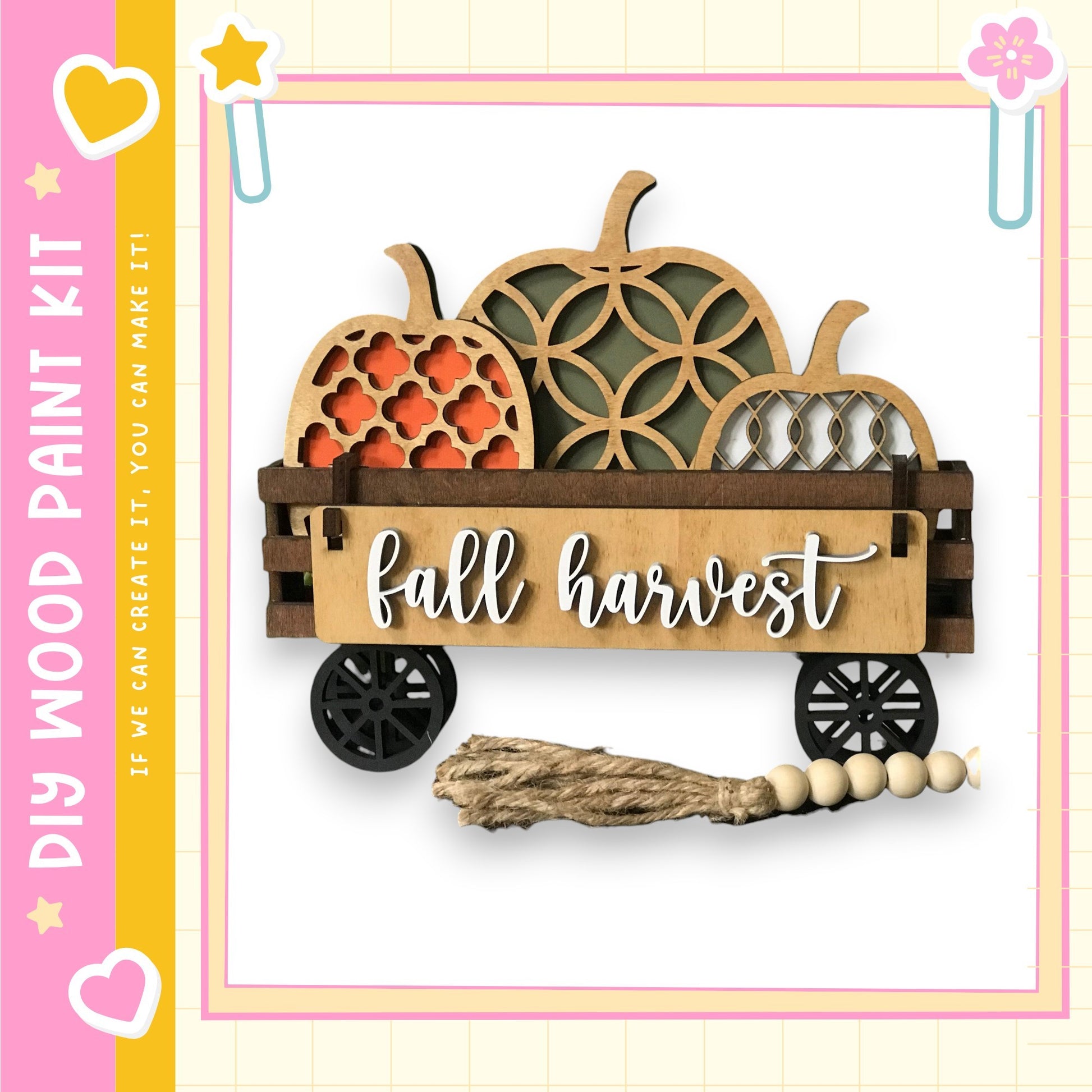 A wooden wagon with carved pumpkins and a sign that says "fall harvest" is displayed against a pink and yellow background.