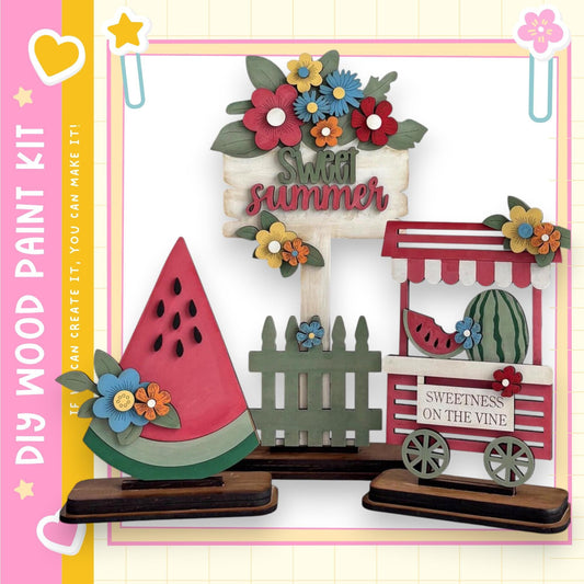 a wooden paint kit with various decorative elements, including a watermelon, flowers, and a sign that says "Sweet summer".