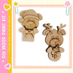 two wooden cutouts of bears, one wearing a hat and the other with antlers, displayed against a pink and yellow background.